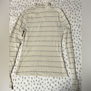 Small turtle neck white black dotted long sleeve shirt.
